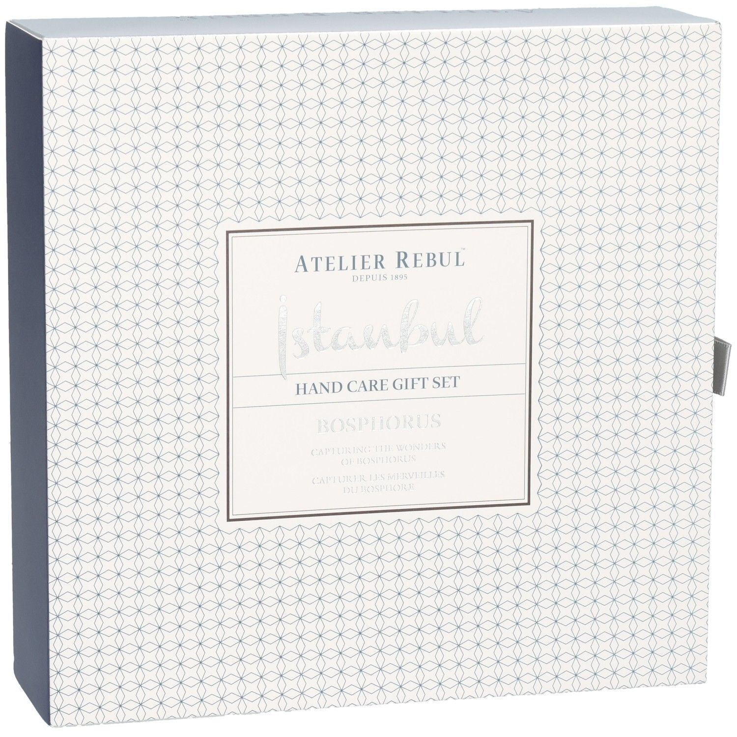 Emballage d'un coffret cadeau pour les mains avec motif géométrique et écriture argentée.