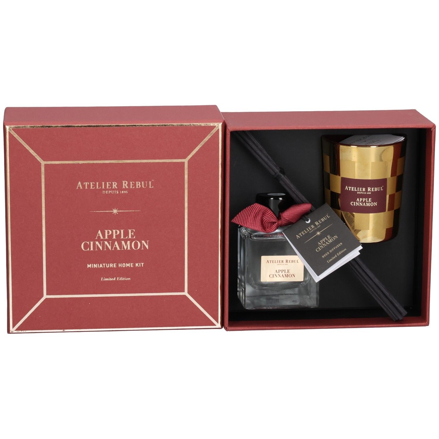 Boîte rouge ouverte avec diffuseur, bougie et bâtonnets parfumés. Inscription: Atelier Rebul, Apple Cinnamon.