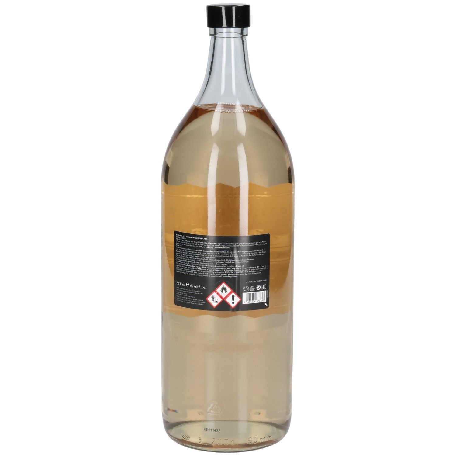 Bouteille en verre transparent avec bouchon noir. Étiquette arrière avec informations produit et symboles de danger.