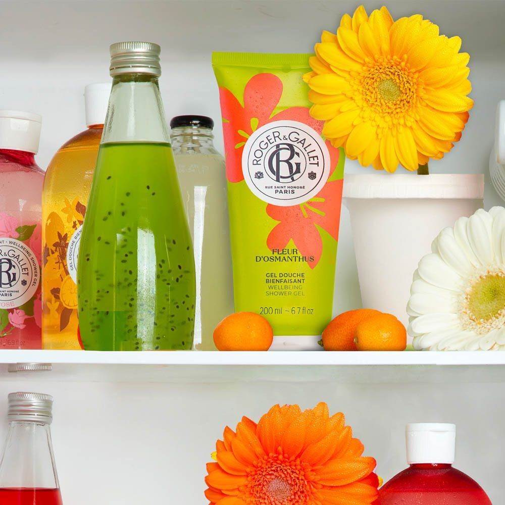 Deux tubes verts de gel douche Roger & Gallet Fleur d'Osmanthus avec fleurs oranges.