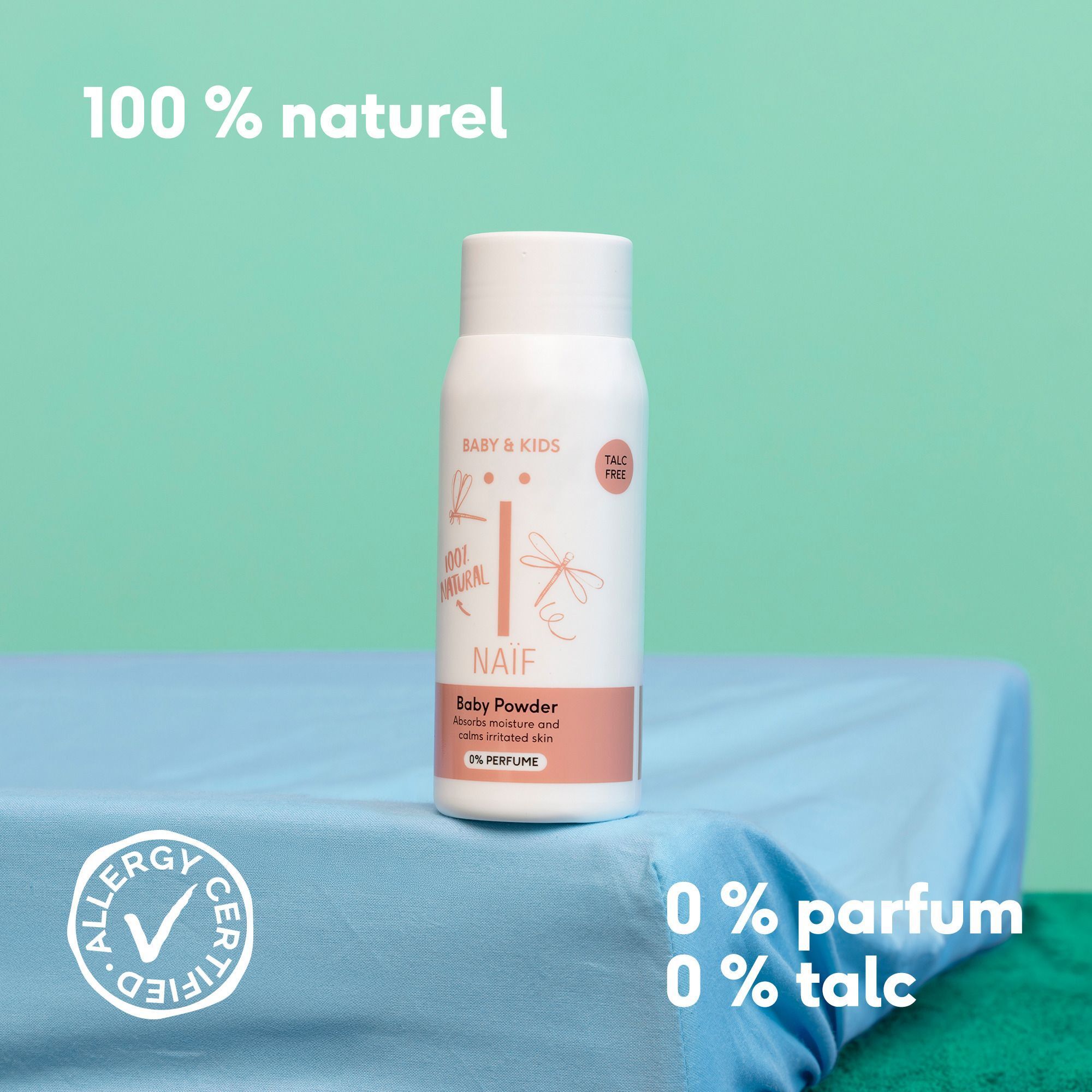 Un flacon de Naïf Baby Powder sur un tissu bleu. Texte : '100% naturel', '0% parfum', '0% talc'. Logo 'Allergy Certified'.