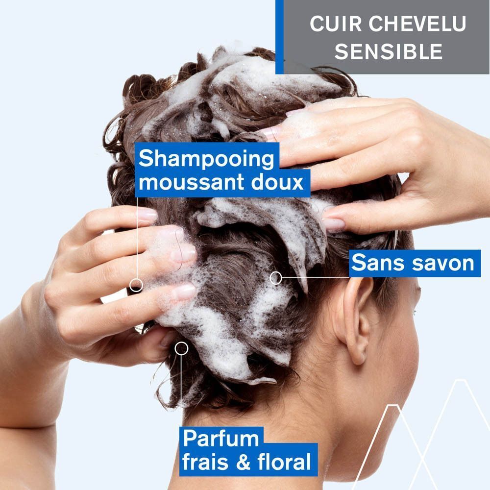 Un flacon bleu Uriage DS Hair Shampooing Doux Équilibrant avec pompe, 500ml, sur une mousse blanche.