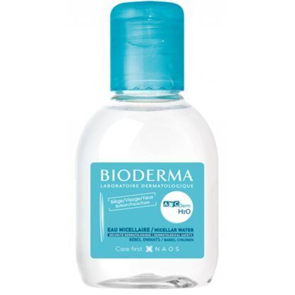 Flacon Bioderma ABCDerm H2O. Bouchon bleu, étiquette bleue et blanche. Liquide clair visible. Nom et logo de la marque présents.