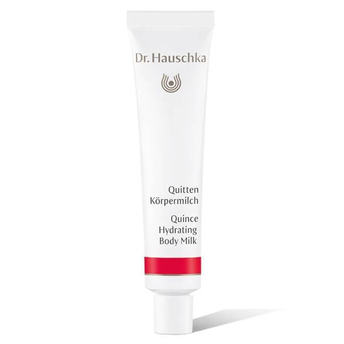 Tube blanche avec bande rouge. Inscription: Dr. Hauschka, Quitten Körpermilch, Quince Hydrating Body Milk.