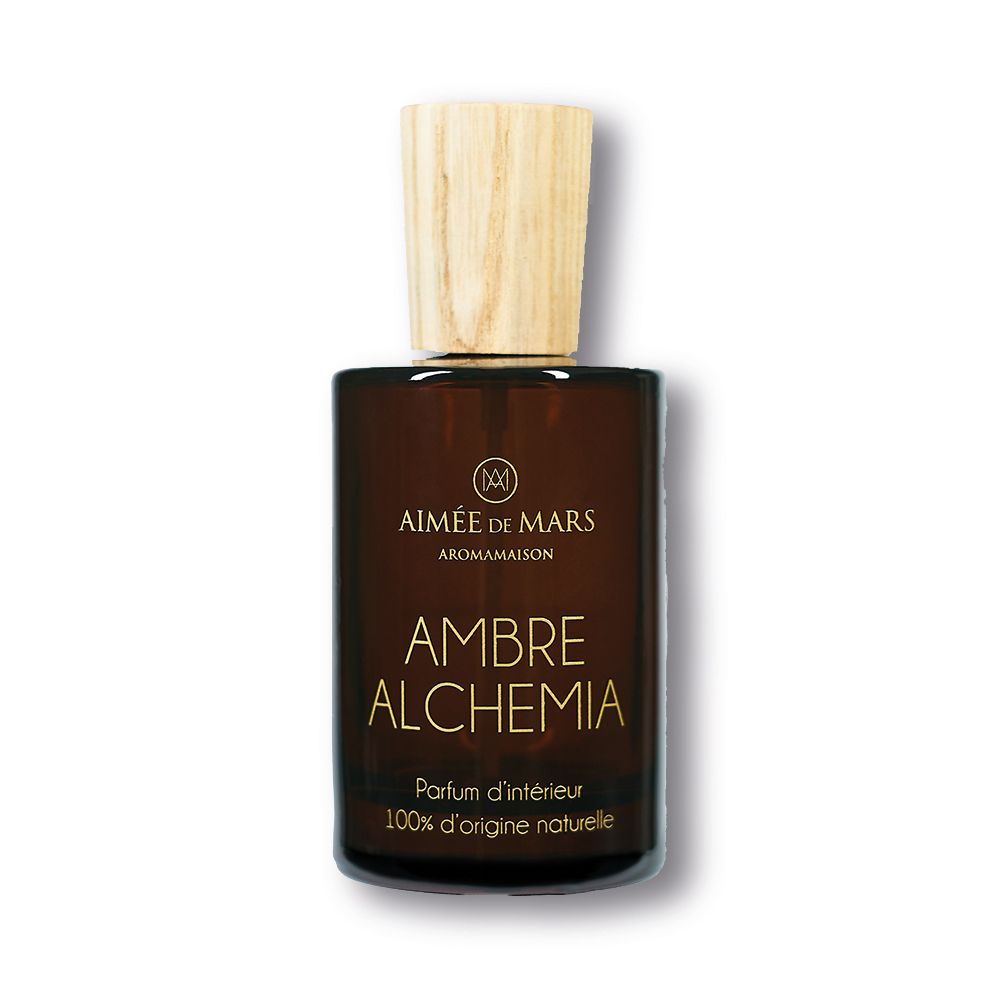 Flacon en verre brun avec bouchon en bois. Inscription: AMBRE ALCHEMIA, Parfum d'intérieur, 100% d'origine naturelle.