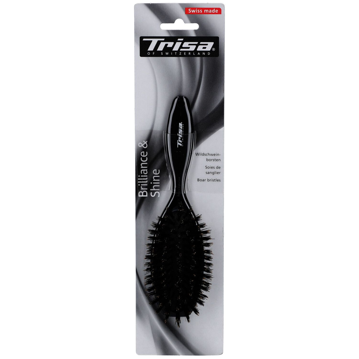 Brosse à cheveux noire avec manche et poils. Sur l'emballage: marque Trisa, inscription Brilliance & Shine, Swiss Made.