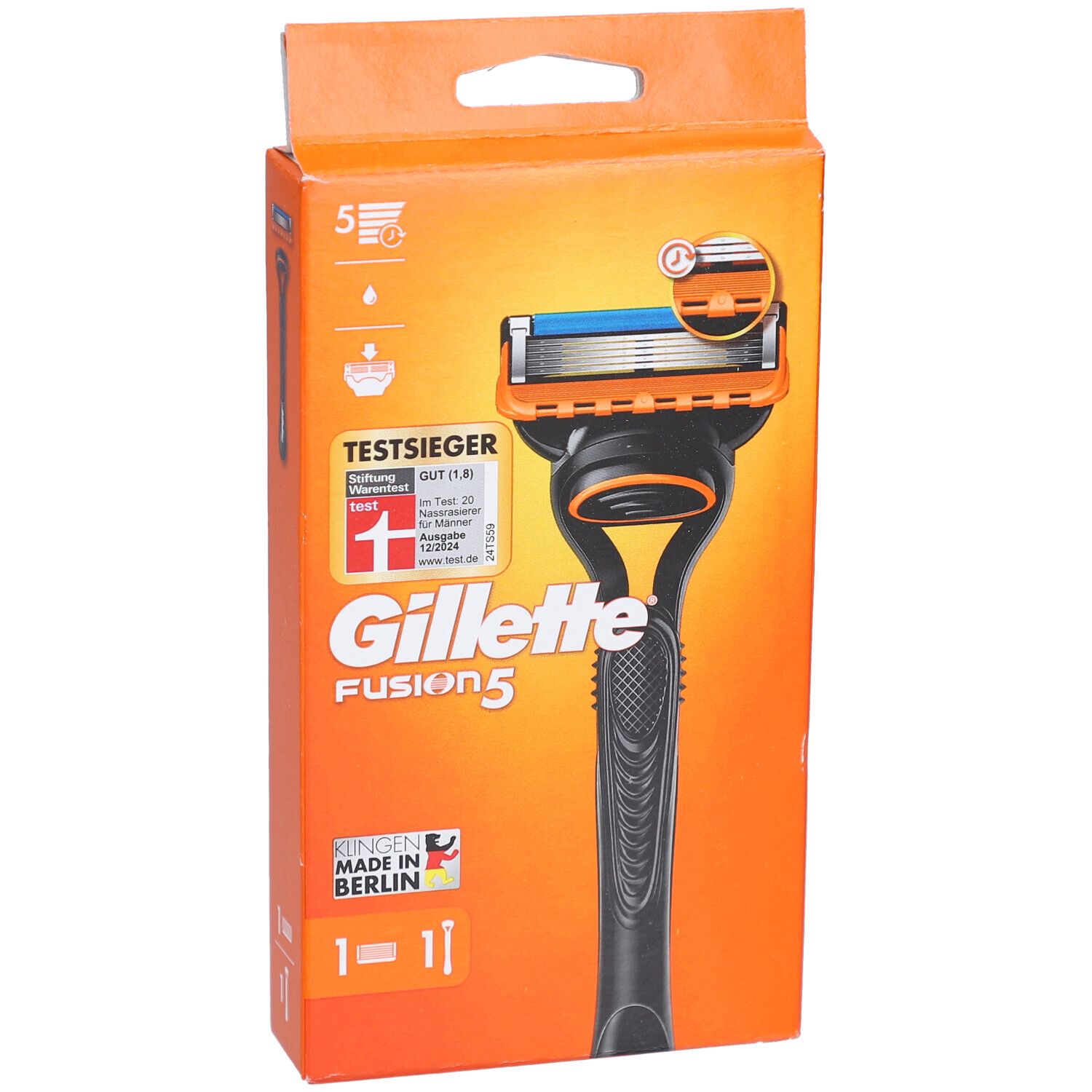 Rasoir dans un emballage orange. Manche noir, tête orange avec lame bleue. Texte: Gillette Fusion5, TestSieger.