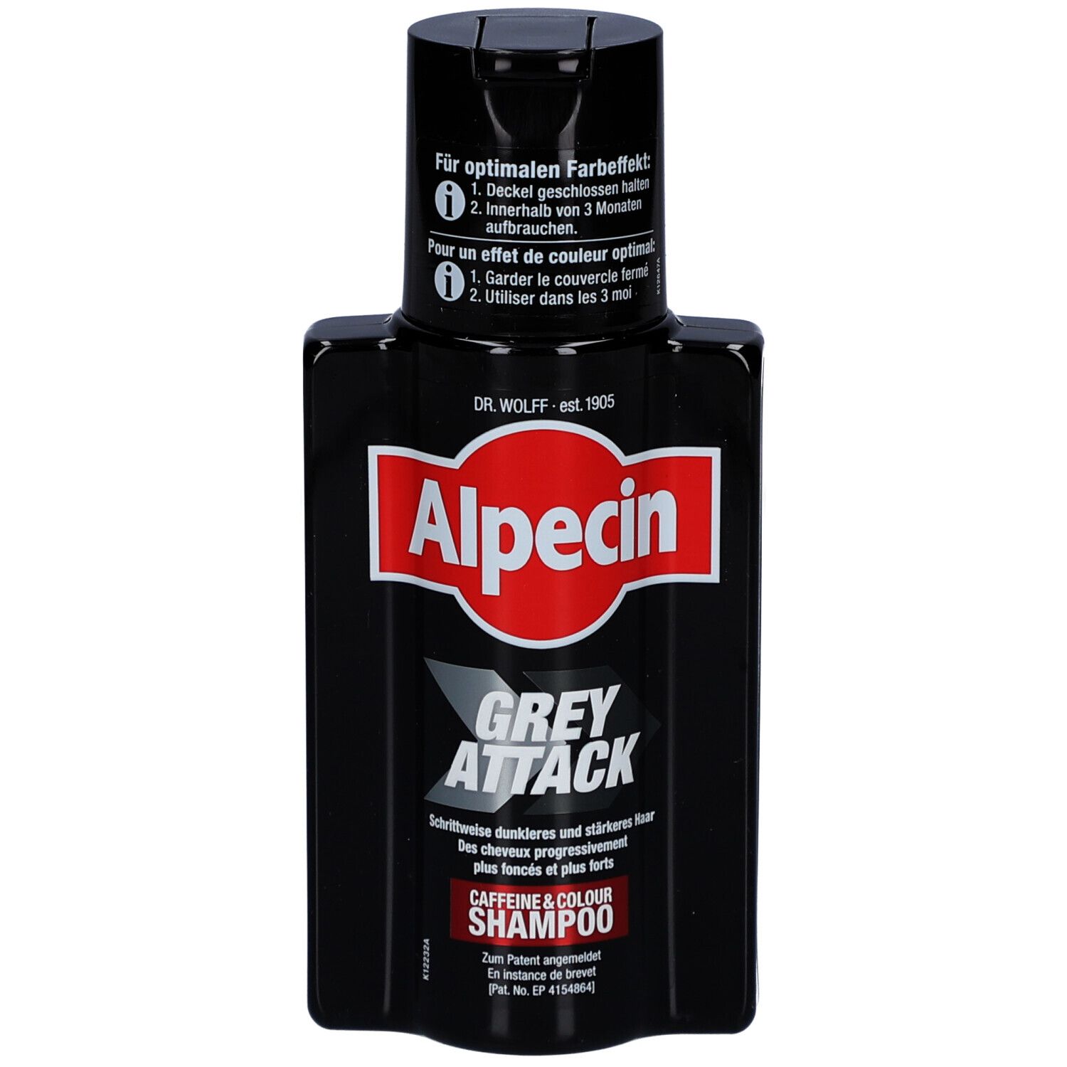 Flacon de shampooing noir avec étiquette rouge. Inscription : Alpecin Grey Attack. Contient du texte en allemand et en français.
