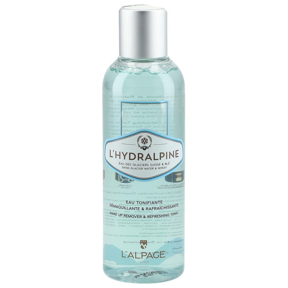 Flacon transparent avec bouchon argenté. Étiquette avec nom L'Hydralpine et texte. Liquide bleu visible.