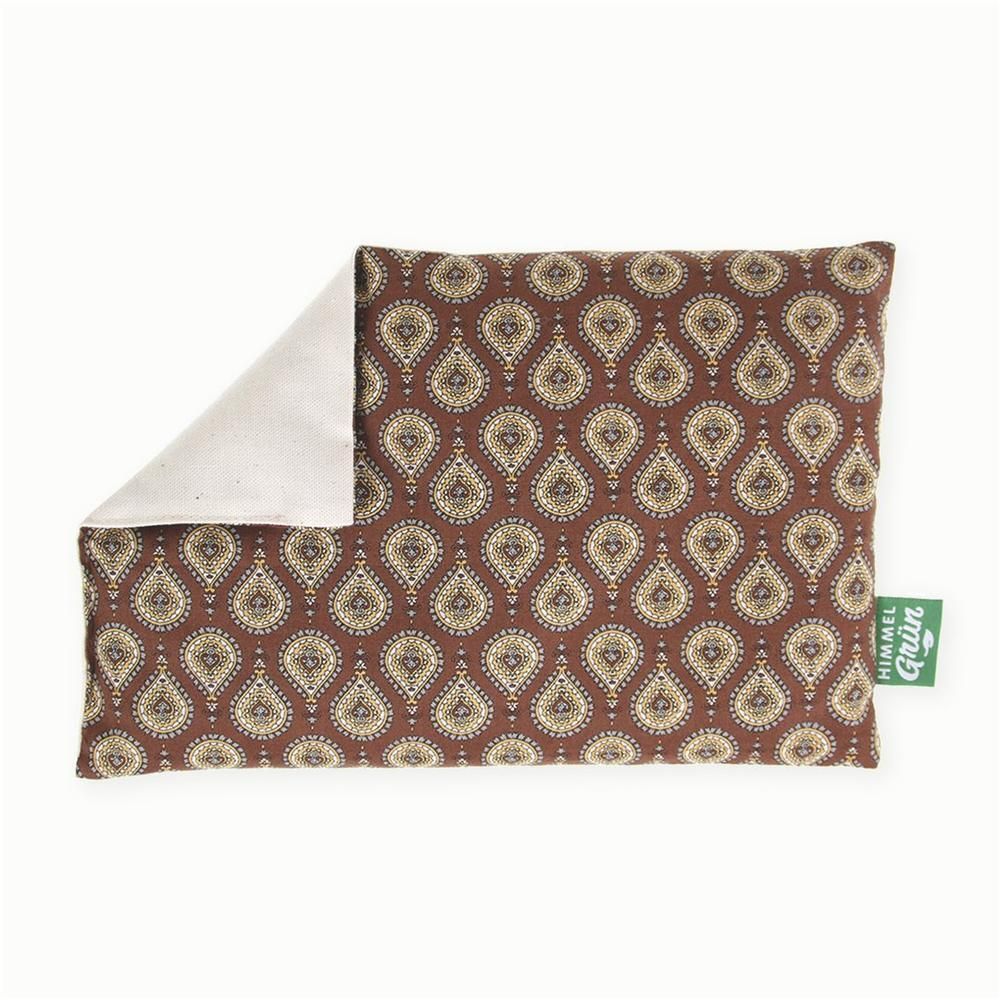 Coussin rectangulaire à motifs bruns. Une partie du coussin est repliée, révélant un tissu crème. Une étiquette verte avec texte est visible.
