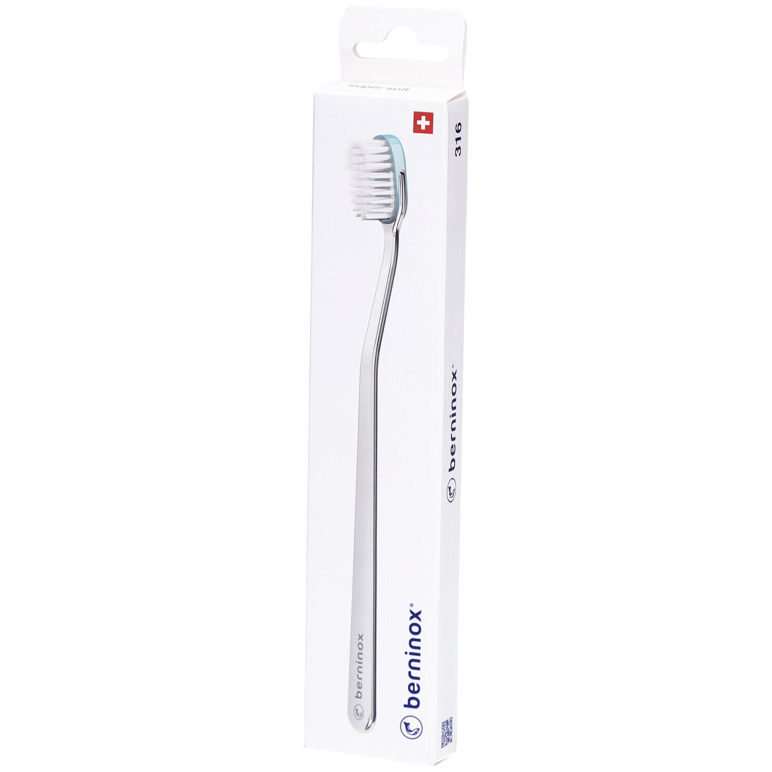 Brosse à dents dans un emballage blanc. Manche argenté, tête blanche et bord bleu clair. Marque Berninox.