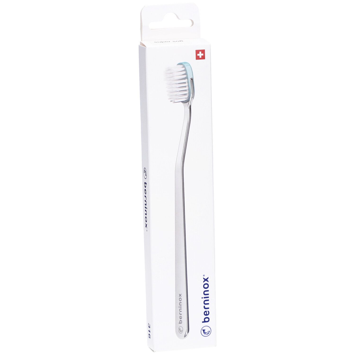 Brosse à dents dans un emballage blanc. Manche argenté, tête blanche et bord bleu clair. Marque Berninox, croix suisse.