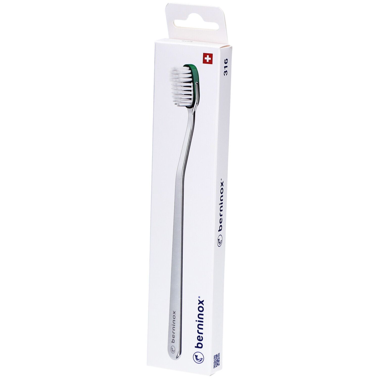 Brosse à dents dans son emballage. Manche argenté, tête verte avec poils blancs. Emballage avec logo et croix suisse.