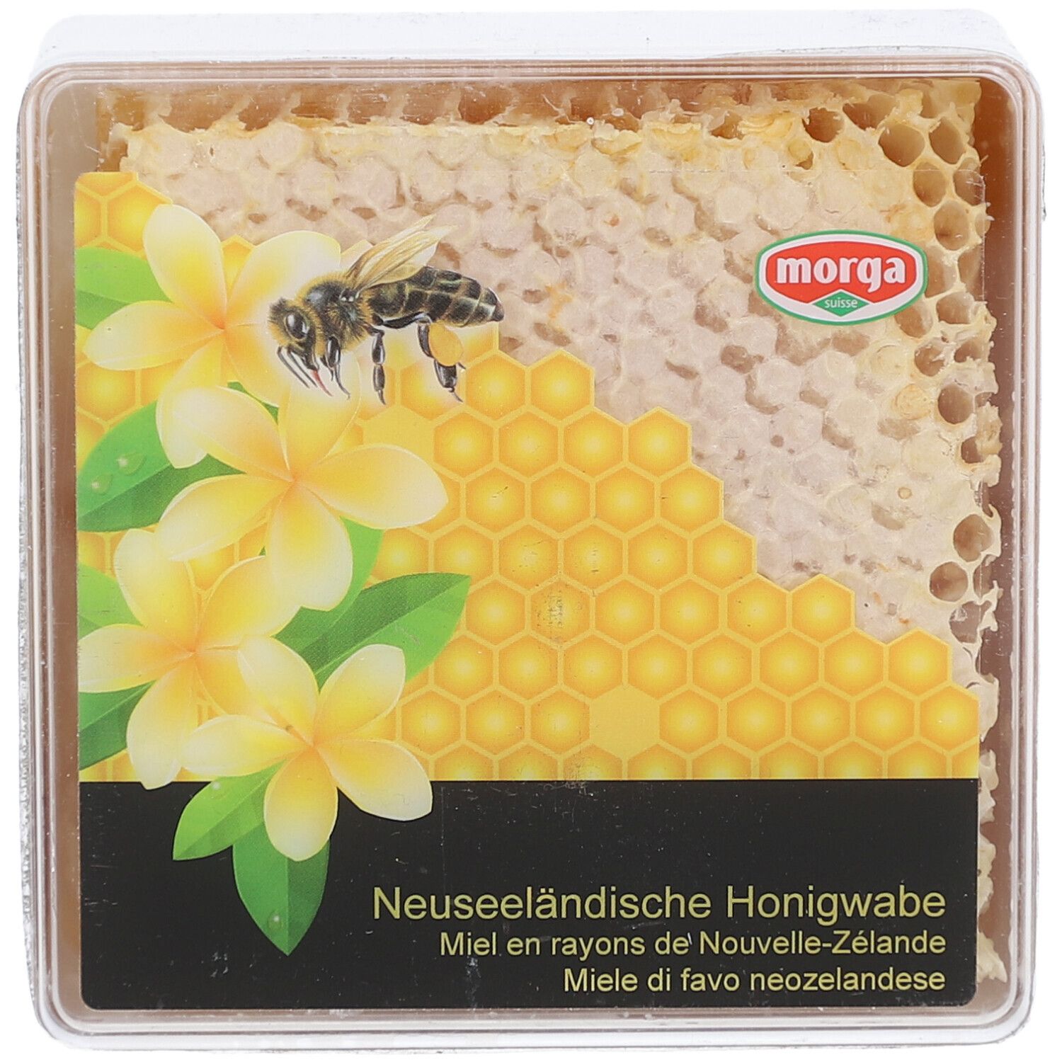 MORGA miel en rayons. Emballage transparent carré avec rayon de miel, fleurs et abeille. Texte: Miel en rayons de Nouvelle-Zélande.