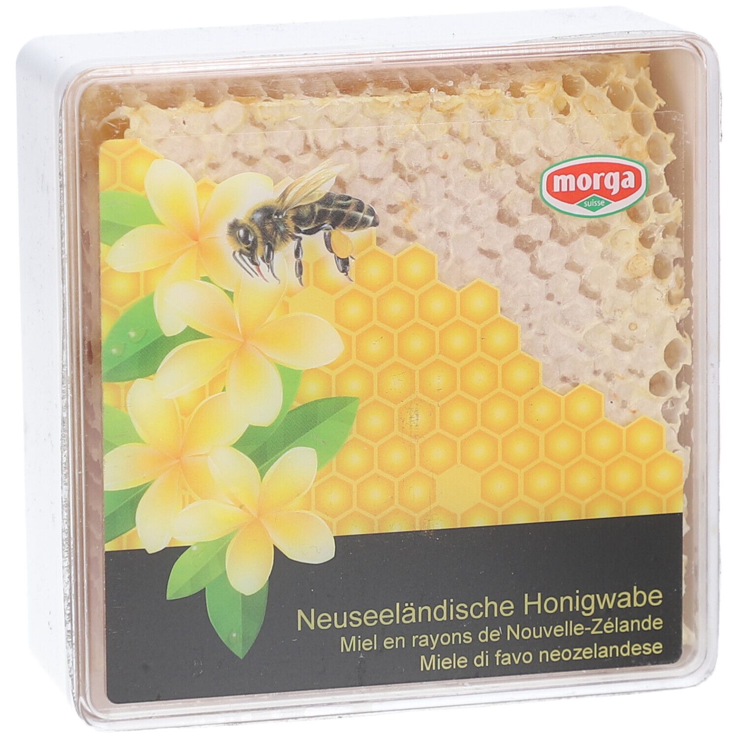 MORGA miel en rayons. Emballage transparent carré avec rayon de miel, fleurs et abeille. Texte: Miel en rayons de Nouvelle-Zélande.