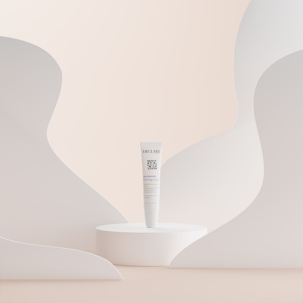 Tube Declare Firming Cream sur socle. Fond avec formes.