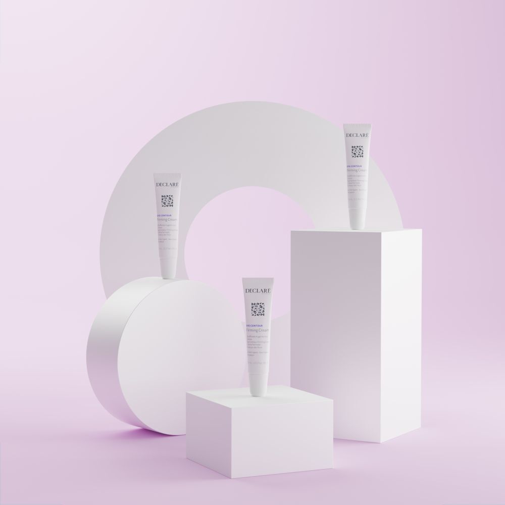 Trois tubes Declare Firming Cream sur socles. Fond avec formes.