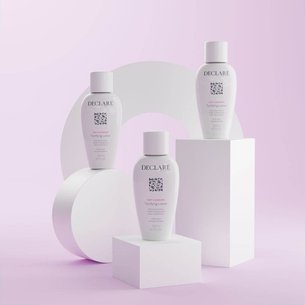 Trois flacons blancs DECLARÉ Toning Lotion sur socles. Inscription : Soft Cleansing, Toning Lotion. Fond : rose.