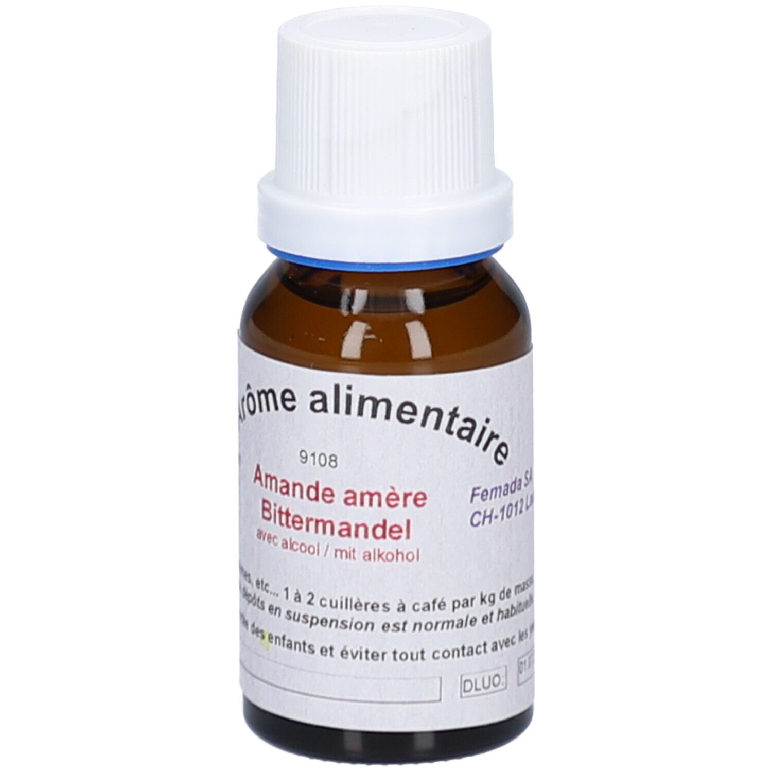 Flacon en verre brun avec bouchon blanc. Étiquette avec texte: Arôme alimentaire, Amande amère, avec alcool. Anneau bleu au col. Adresse du fabricant.