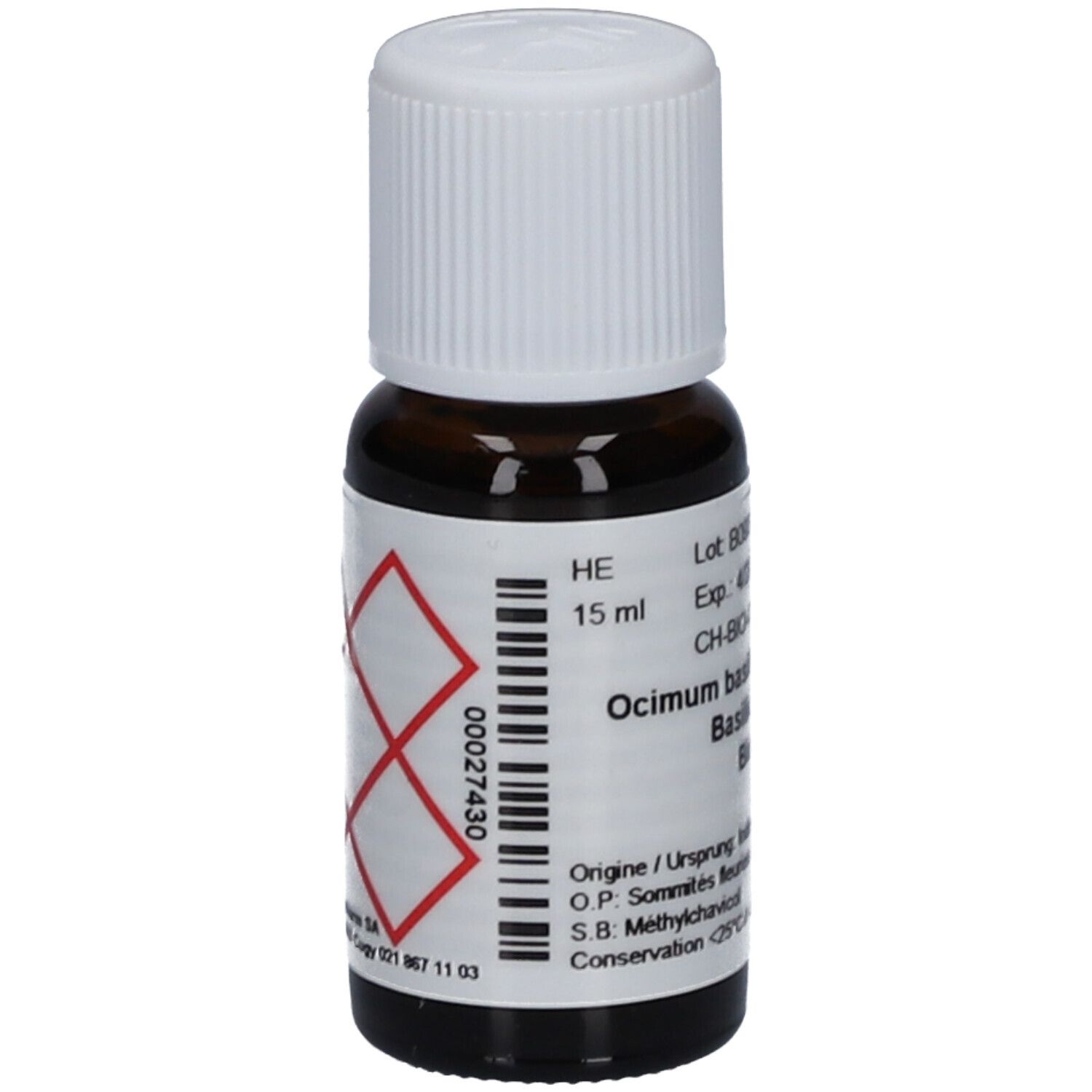 Flacon en verre brun avec bouchon blanc. Étiquette avec texte: Ocimum basilicum, Basilic tropical Bio. Symbole de danger. 15 ml.