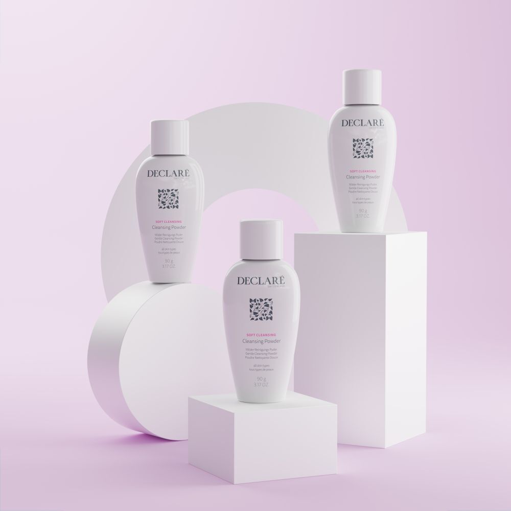 Trois DECLARÉ Soft Cleansing Poudre sur socles. Produit blanc, logo, nom, informations. Fond avec formes.