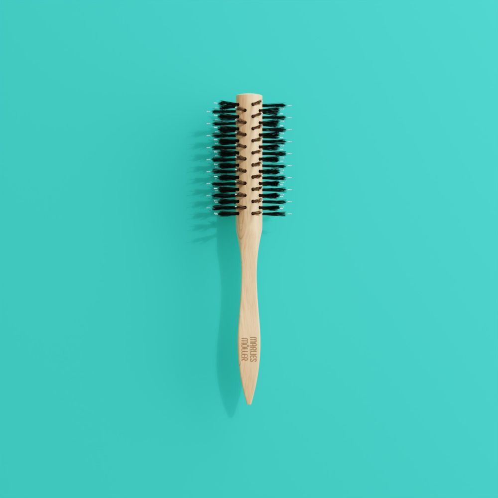 Brosse à cheveux ronde sur fond turquoise. Manche en bois, poils noirs.