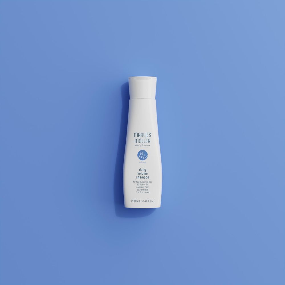 Flacon de shampooing blanc sur fond bleu. Inscription: Marlies Möller, Volume Daily Volume Shampoo. 200ml.