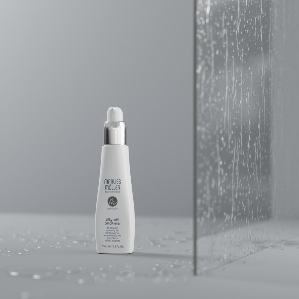 Flacon blanc avec pompe. Inscription: Marlies Möller, Pashmisilk Silky Milk Conditioner. Devant verre.