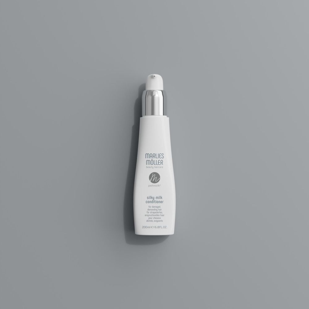 Flacon blanc avec pompe. Inscription: Marlies Möller, Pashmisilk Silky Milk Conditioner. Sur fond gris.