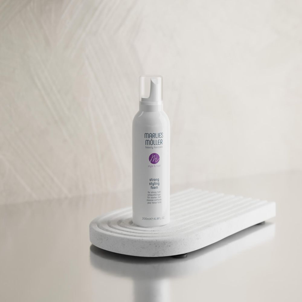 Flacon blanc sur socle blanc. Inscription: Marlies Möller, Style & Hold, Strong Styling Foam. 200ml.