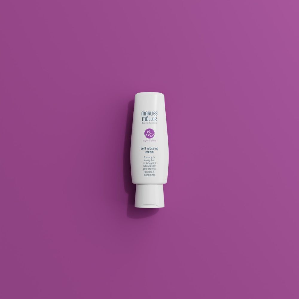 Tube blanc, Marlies Möller Soft Glossing Cream, sur fond violet. Produit debout.
