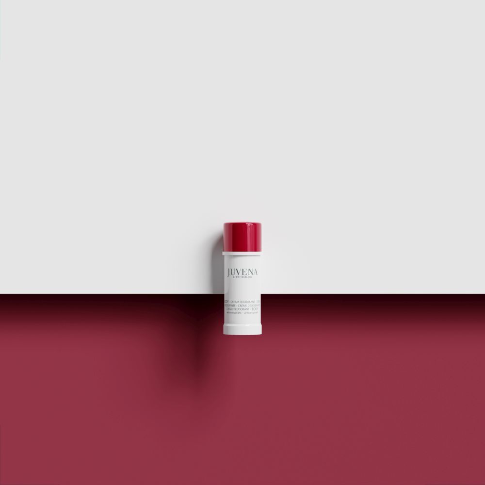 Stick de déodorant à bouchon rouge sur fond blanc et rouge. Nom du produit illisible.
