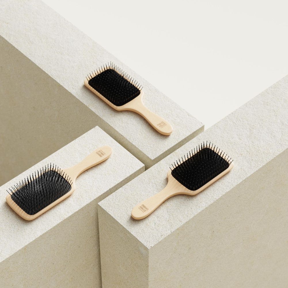 Trois brosses à cheveux sur des socles. Manche en bois, coussinet noir.