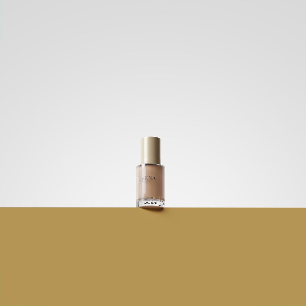 Fluide Teinté Delining Juvena SPF 10, flacon sur un socle.