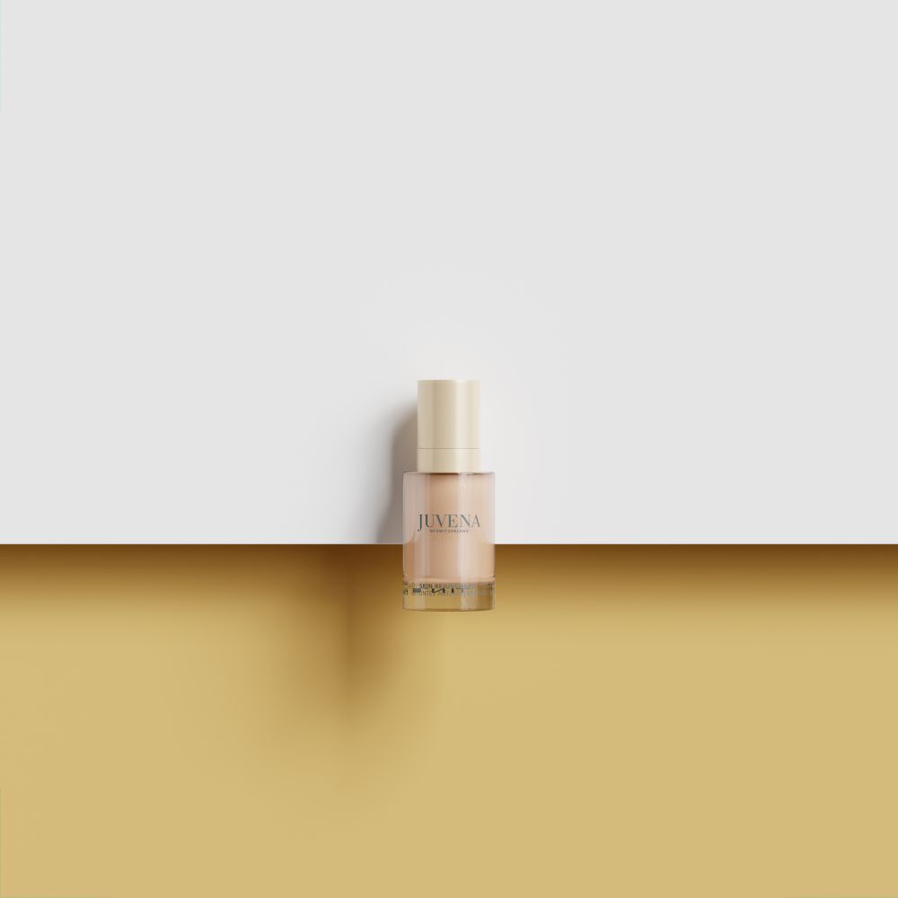 Fluide Teinté Delining Juvena SPF 10, flacon sur fond divisé.