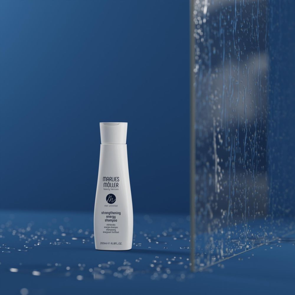 Marlies Möller Strengthening Energy Shampoo sur fond bleu avec gouttes d'eau.
