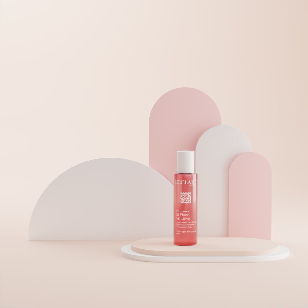Un flacon de liquide rose sur un socle. Fond avec des formes roses et blanches.