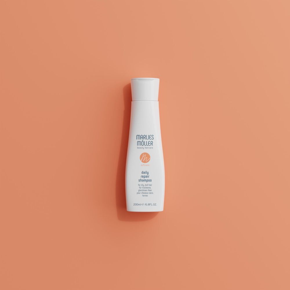 Flacon de shampooing blanc sur fond orange. Inscription: Marlies Müller, daily repair shampoo. 200ml/6.8FL.OZ.