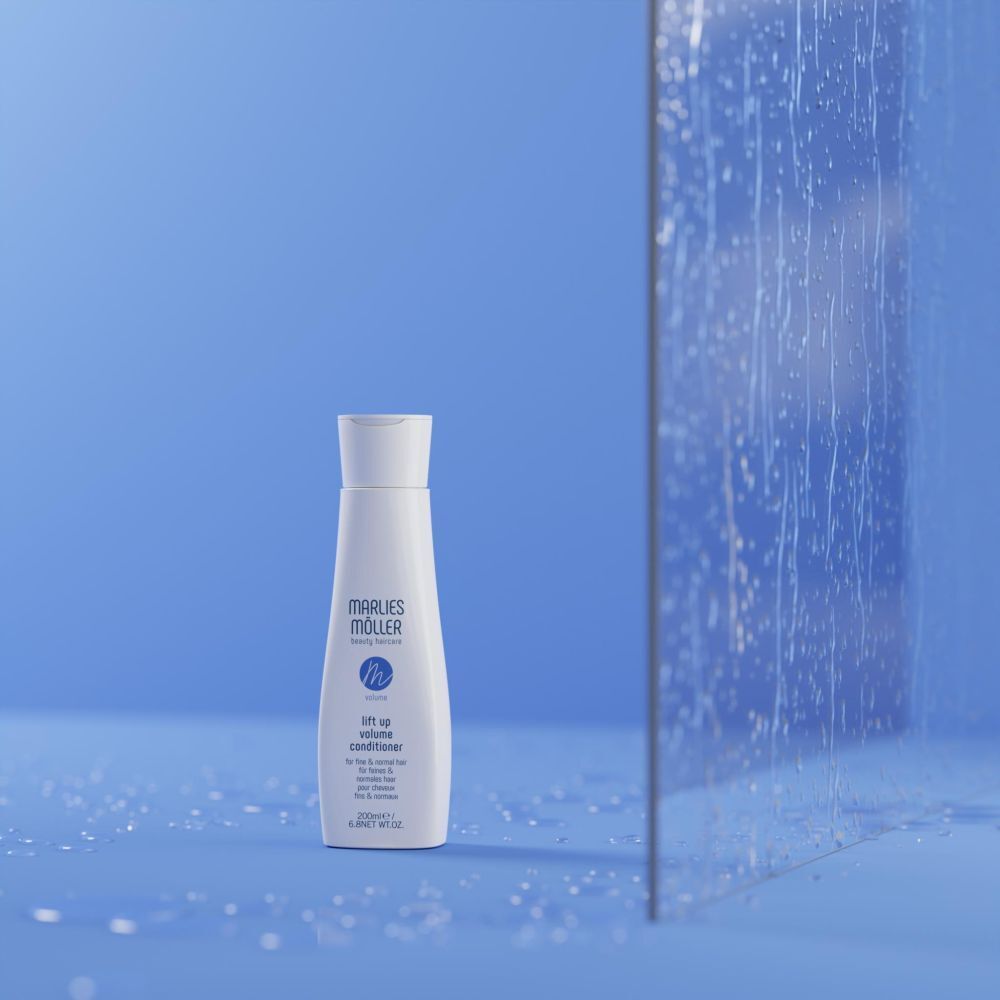 Bouteille Marlies Möller Volume Conditioner sur fond bleu avec gouttes d'eau et paroi vitrée.