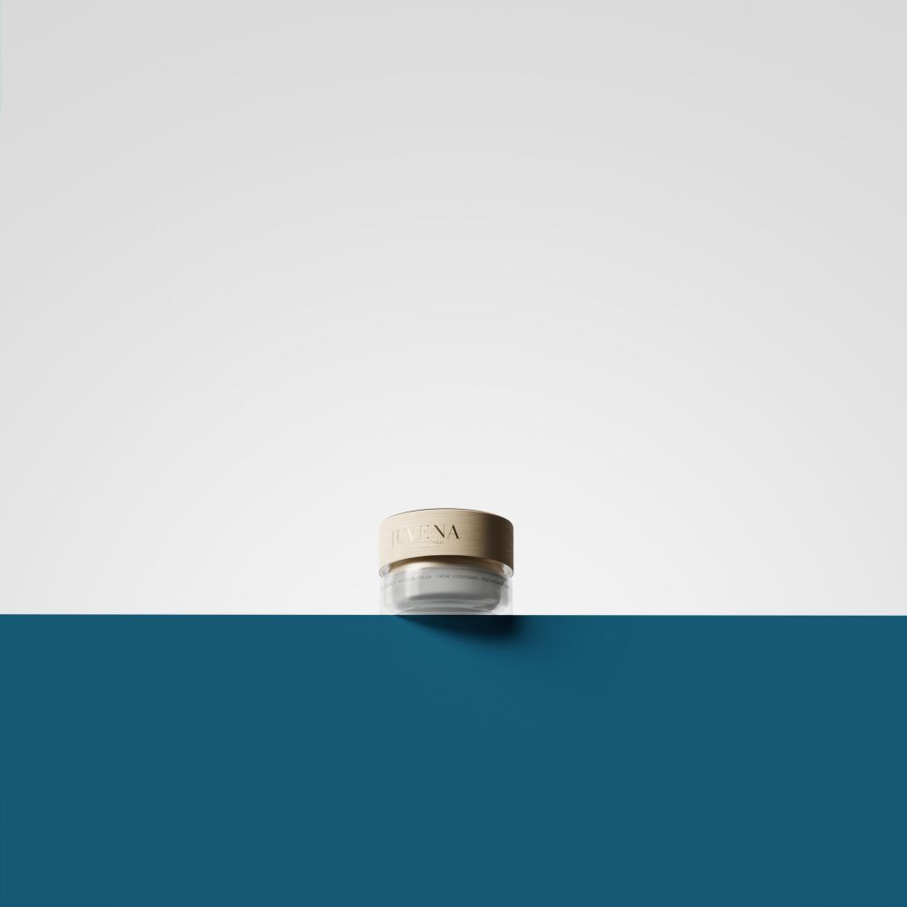 Petit pot en verre avec couvercle doré, posé sur une surface bleue et blanche.