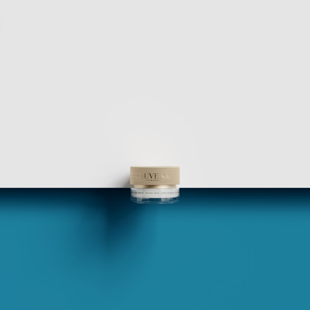 Pot en verre avec couvercle doré sur une surface bleue et blanche.