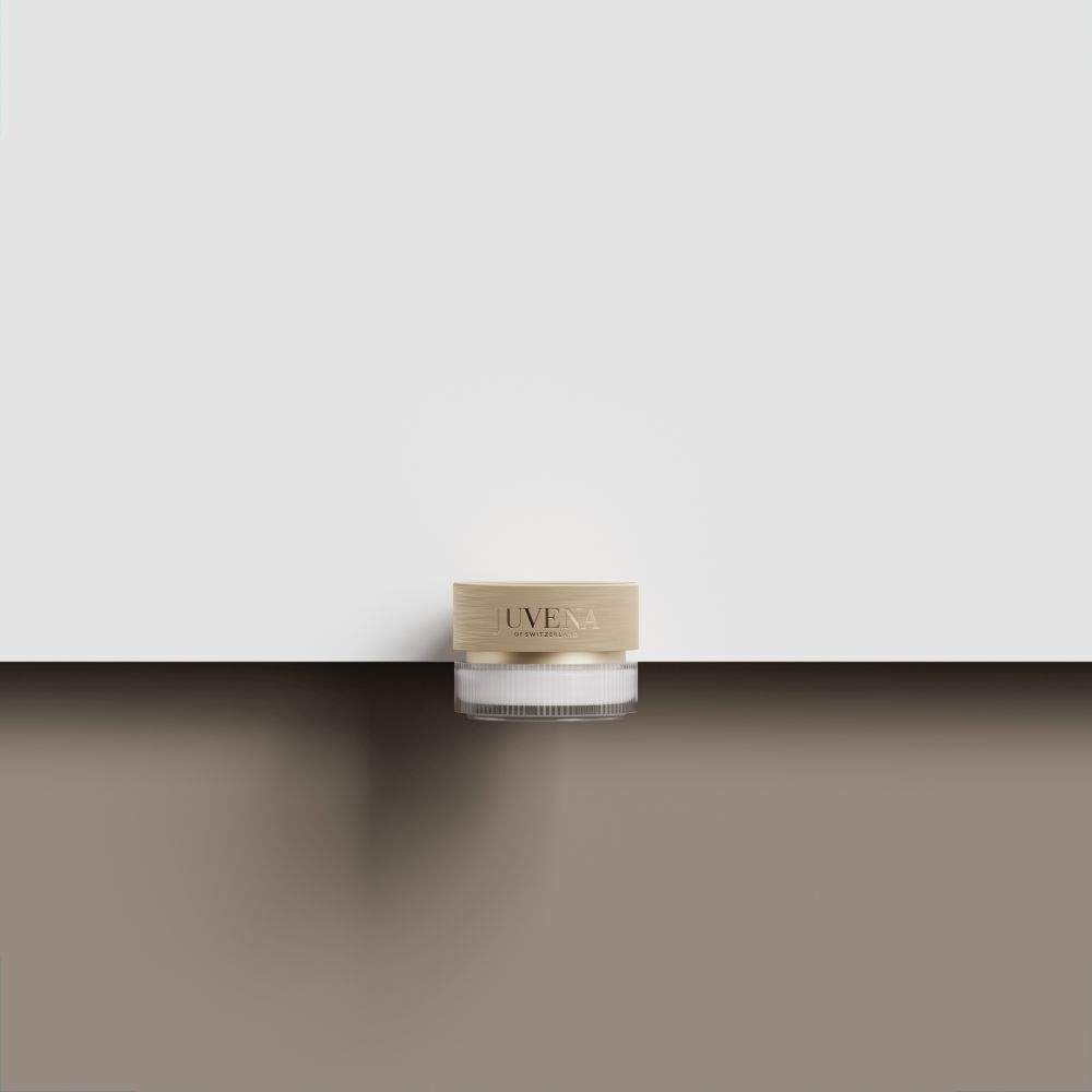 Pot de crème avec couvercle doré. Sur surface marron. Fond blanc.