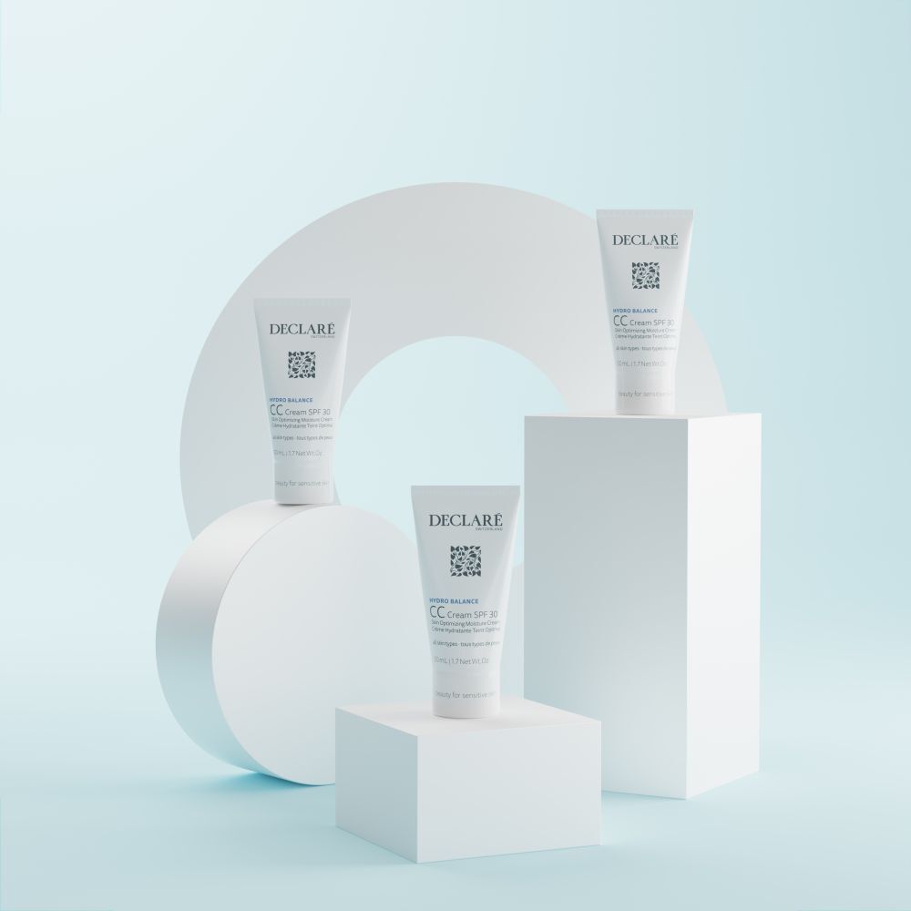 Trois tubes DECLARÉ CC Cream SPF 30 sur des blocs blancs. Fond avec cercle blanc.