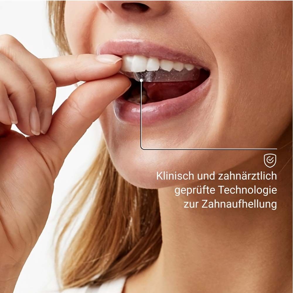 Femme plaçant des bandes blanchissantes dans sa bouche. Testé cliniquement et par des dentistes.