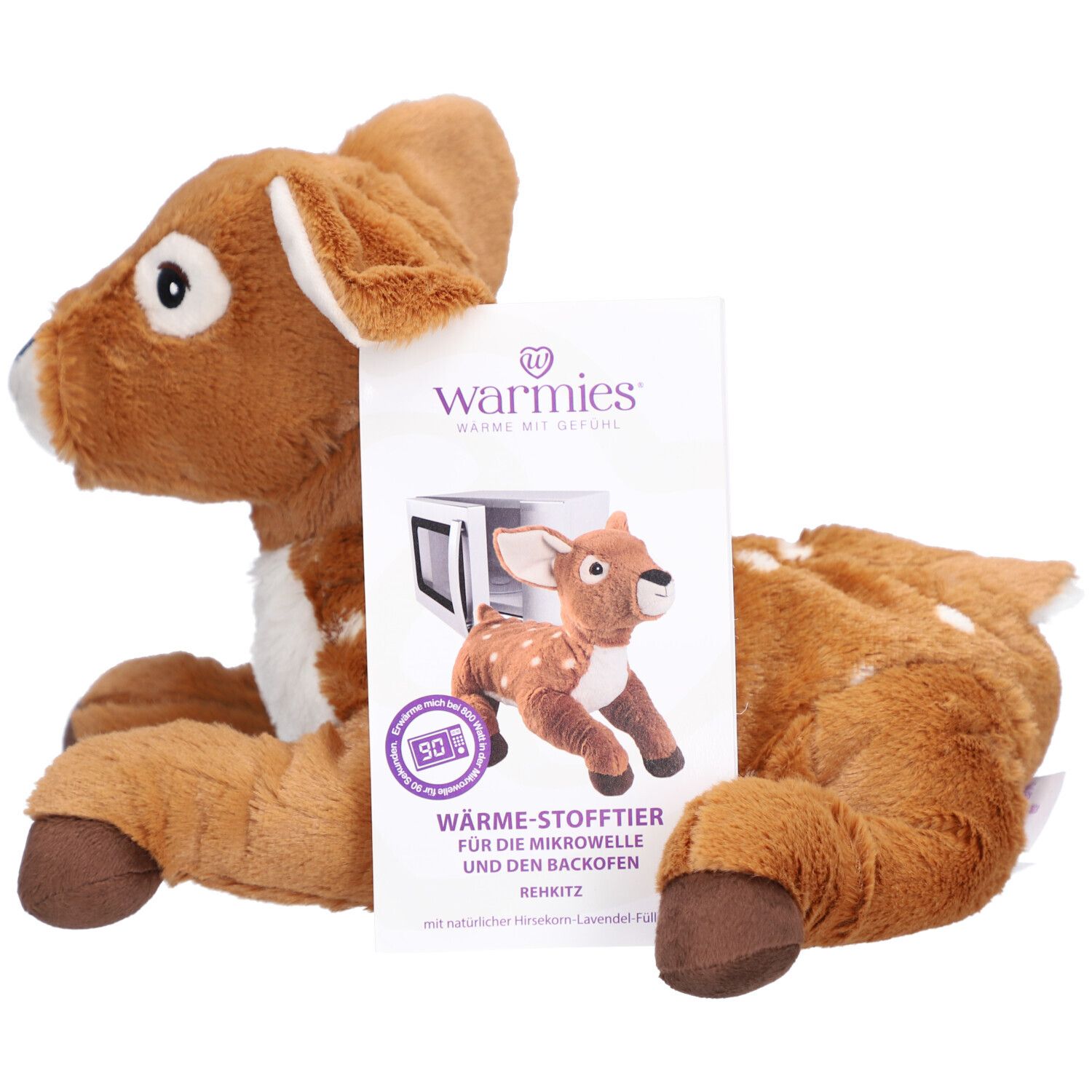 Faon en peluche marron avec des taches blanches et emballage. Emballage avec image du produit et texte. Oreilles, ventre et pieds brun clair.