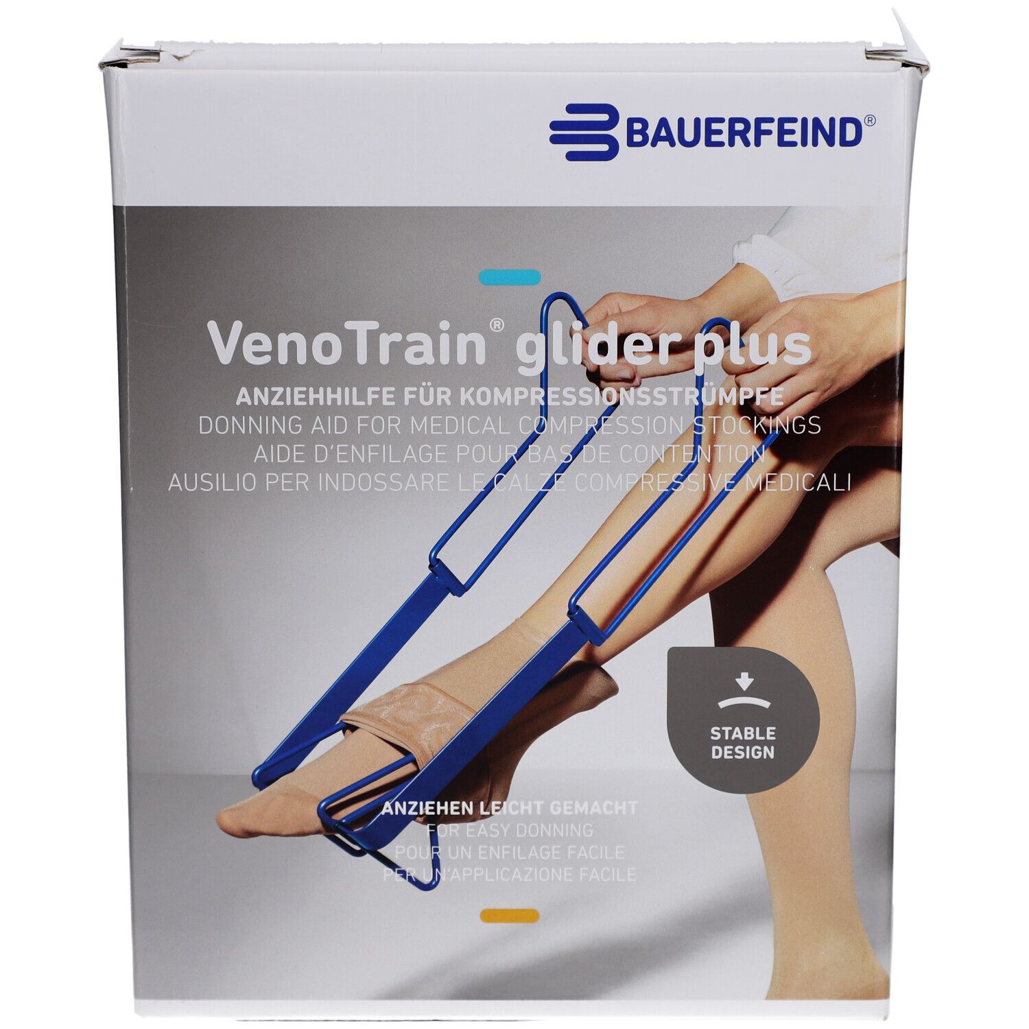 Aide à l'enfilage en cours d'utilisation. Aide bleue avec poignées et jambe dans bas. Marque et nom du produit visibles.