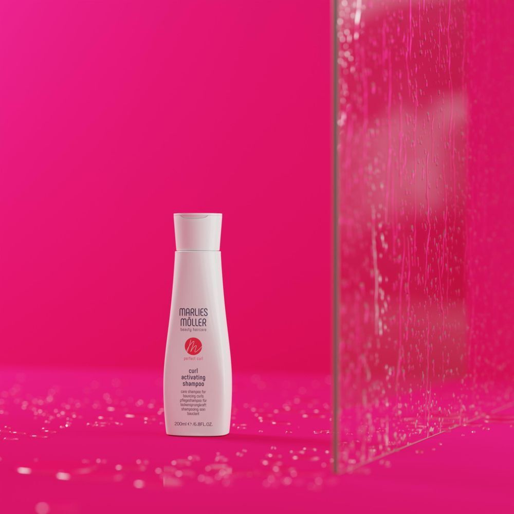 Flacon de shampooing Marlies Möller sur fond rose. Nom du produit et logo visibles.