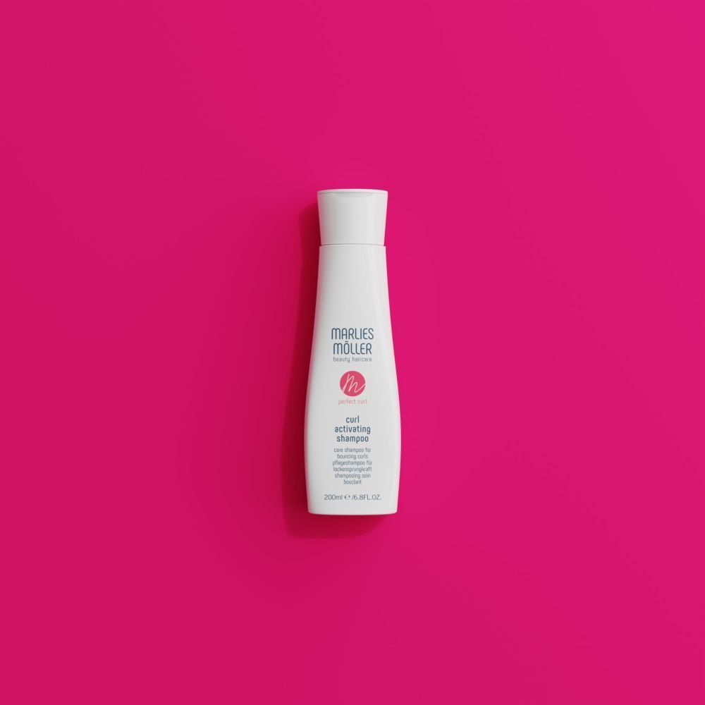 Flacon de shampooing Marlies Möller sur fond rose. Nom du produit et logo visibles.