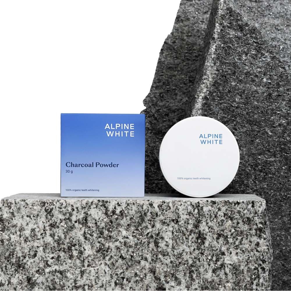 Boîte et pot bleus sur pierre. Texte: ALPINE WHITE, Charcoal Powder, 30 g.