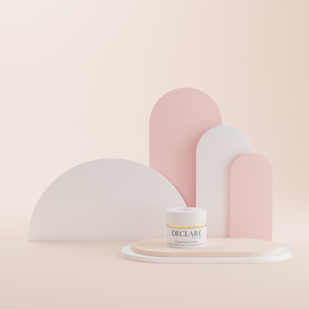 Pot blanc sur socle. Inscription DECLARÉ Couperose Solution. Fond : formes roses et blanches.